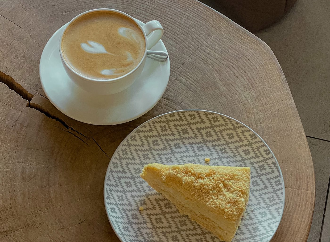 latte on a table next to a slice of pie